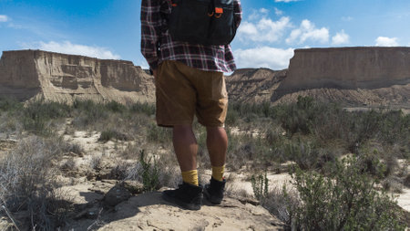 Middle-aged lone hiker walks into the distance in the desert of Las Bardenas Reales