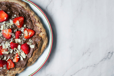 A chocolate pizza with strawberries and almonds with room for text.の写真素材