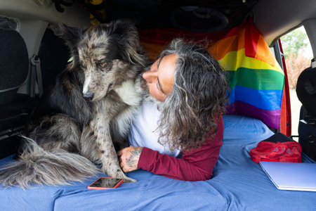 Caucasian man with his pet inside a mini van Digital nomad lifestyleの写真素材