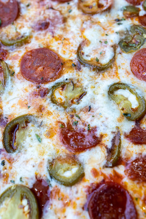 Close up of a Mexican pizza with pepperoni, jalapenos and mozzarella. macro viewの写真素材