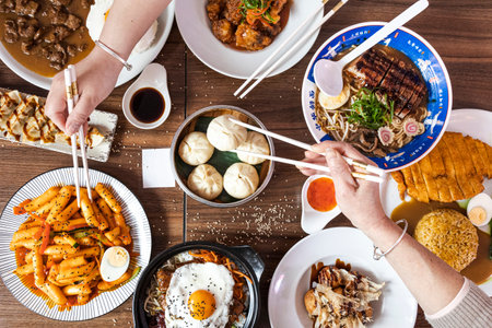 Chinese food on restaurant table including Xiao Long Bao, Tokbokki and Duck Ramenの写真素材