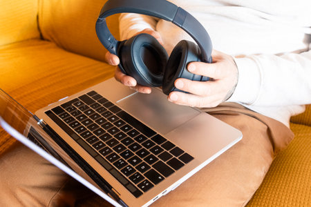Man using laptop with headphones. Concept of audio books and distance classesの写真素材