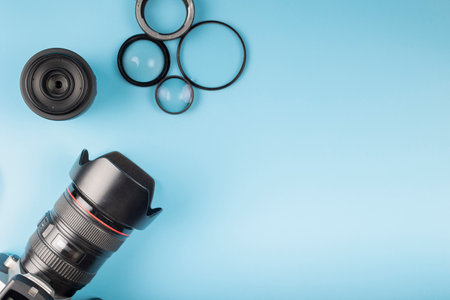 Photo camera, lenses and photographer's equipment on a blue background with space for text. Photographer's day conceptの写真素材