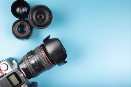 Photo camera, lenses and photographer's equipment on a blue background with space for text. Photographer's day conceptの写真素材