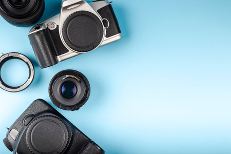 Photo camera, lenses and photographer's equipment on a blue background with space for text. Photographer's day conceptの写真素材