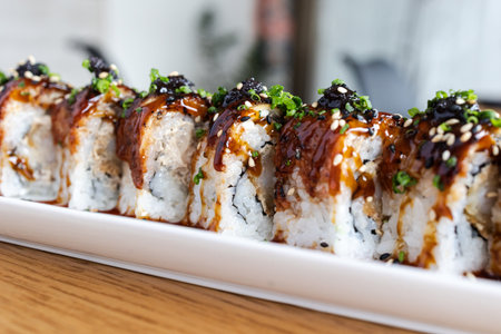 Delicious Japanese sushi rolls arranged on a white serving plate, ready for eating