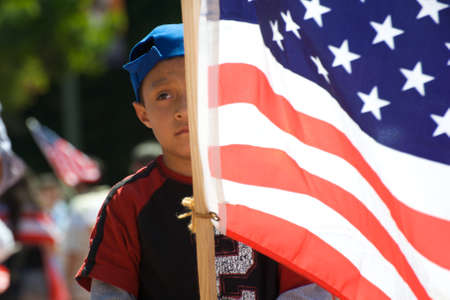 Los Angeles, USA, May 5, 2010: Boy holding an american flag during an Immigration march in Downtown Los Angeles のeditorial素材