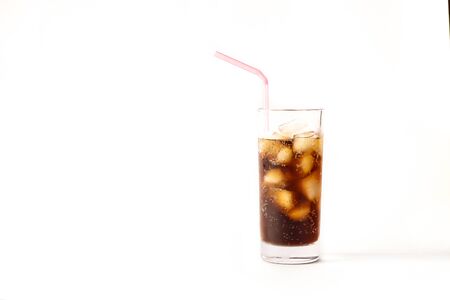 Glass full of soft drink with ice and a straw in a white background