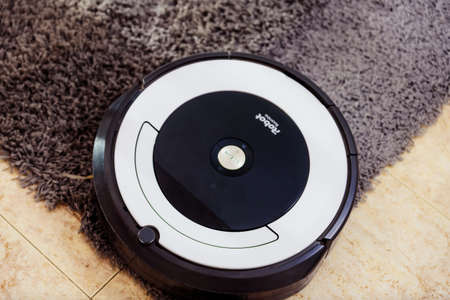 Berlin, Germany, August 29, 2019. irobot vacuum cleaner roomba cleaning a gray carpet. home cleaning concept.のeditorial素材