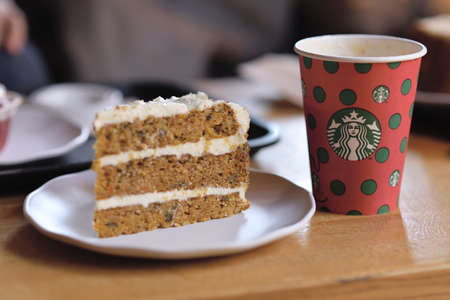 Paris , France-September 27, 2019: A tall Starbucks coffee in starbucks coffee shop with cake. Starbucks is the world's largest coffee house with over 20,000 stores in 61 countries.のeditorial素材