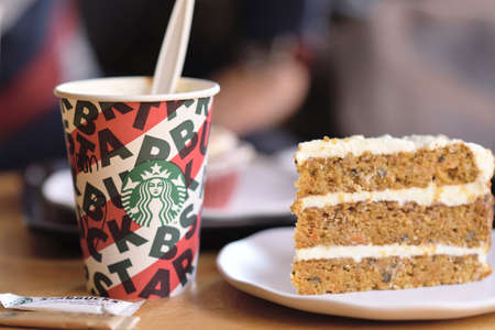 Paris , France-September 27, 2019: A tall Starbucks coffee in starbucks coffee shop with cake. Starbucks is the world's largest coffee house with over 20,000 stores in 61 countries.のeditorial素材