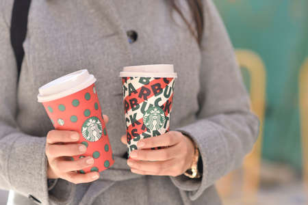 New York, USA - November 5, 2019 : Close up of a Woman drinking a tall Starbucks coffee on the...