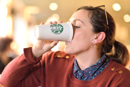 WARSAW - APR 08: An Unidentified man holding a cup of beverage from Starbucks cafe in Warsaw on...