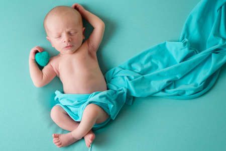 Newborn sleeping baby boy on a blue blanket.の写真素材