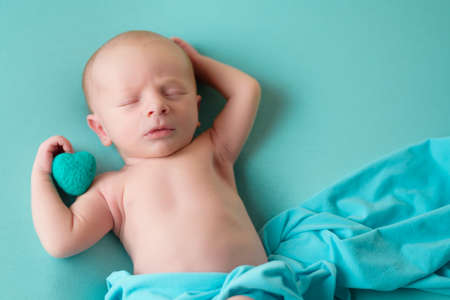 Newborn sleeping baby boy on a blue blanket.の写真素材