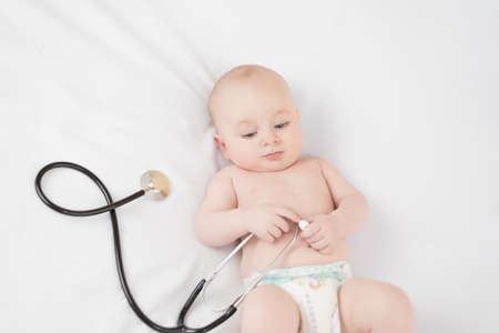 Sweet baby with stethoscope on a white backgroundの写真素材