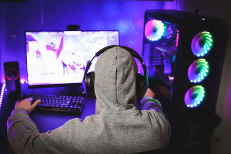 Professional gamer in his expensive studio young man having live stream playing online video game. Cyber sportsman is streaming popular pc computer game for his followersの写真素材