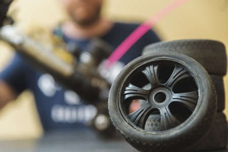 Young Caucasian male assembling toy RC car at home in the evening