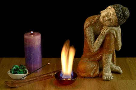 Light scented candles and incense, create a climate of peace and serenity  Along with candles, a figure of Buddha の写真素材