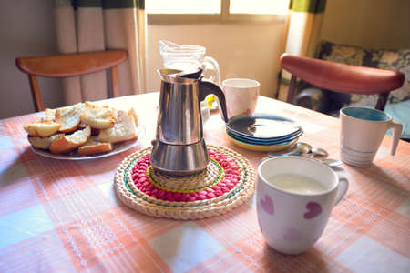 Coffee maker with coffee, milk and toast arranged on a tableの写真素材