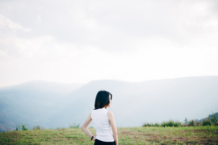 Asian girl standing amid mountainous scenery.の写真素材