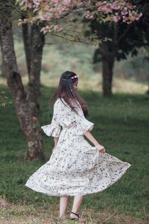 Teenage Asian girl in white dress enjoys the park.の写真素材