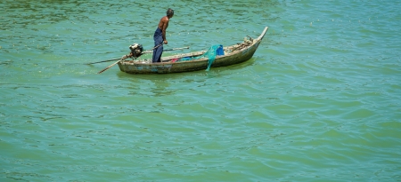 Old fisherman going out to sea in the Gulf of Thailandの写真素材