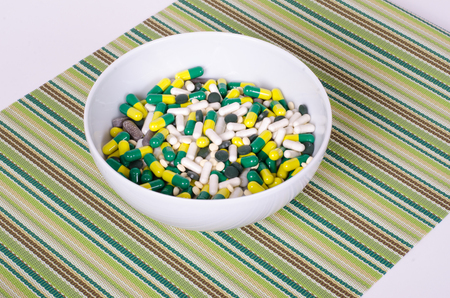 Plate of pills on striped cloth isolated, concept diet, diseasesの写真素材