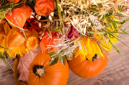 Autumn bouquet, pumpkins, cape gooseberry on wooden backgroundの写真素材