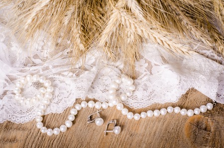 Lace, pearl necklace, earrings and ears of cornの写真素材