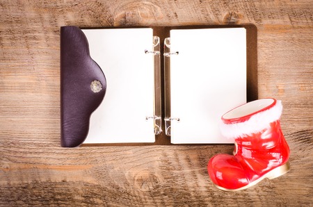 Santa Claus boots and blank wish book on wooden background, New Year and Christmas decoration, card. Free space for text.の写真素材