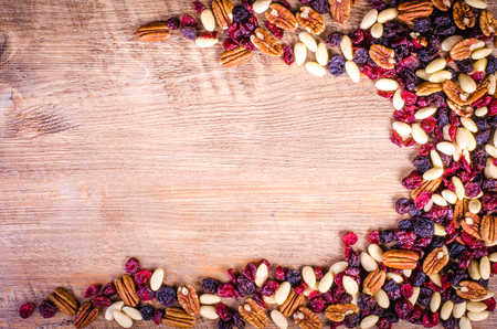 Dried fruits - pecan, cranberry, raisin, almond on wooden background.の写真素材