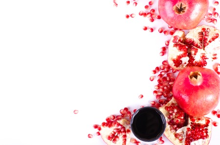 Glass of fresh pomegranate juice and ripe pomegranate fruit, seeds isolated on white background. Eating frame.の写真素材