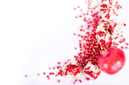 Ripe pomegranate fruit and seeds on wooden background. Eating frame.の写真素材