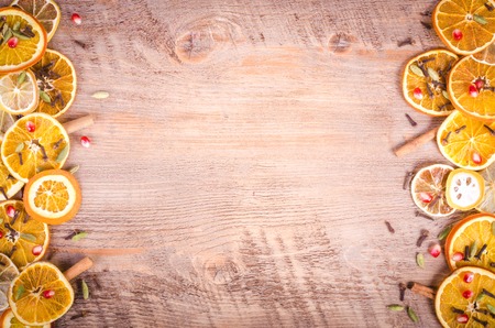 Slices of dried orange, lemon, cinnamon, cloves, cardamom and pine cone. Christmas and New Year decoration. Free space for text.の写真素材