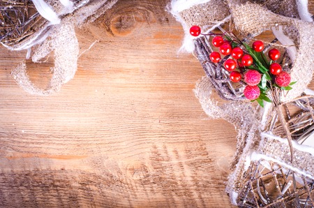 Christmas rustic light boxes on wooden background, sprig of berries, snowy wreath. Christmas and New Year decoration frame. Free space for text.の写真素材