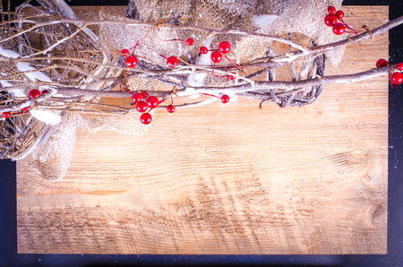 Christmas rustic light boxes on wooden background, snowy wreath, berries. Christmas and New Year decoration frame. Free space for text.の写真素材