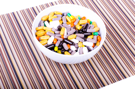 Plate of pills on striped cloth isolated, concept diet, diseasesの写真素材