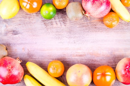 Fresh fruits on wooden background. Summer background. Raw and vegetarian eating background. Lemon,...