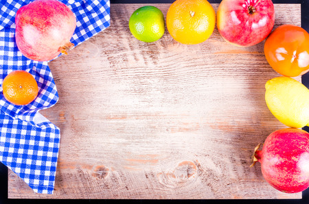 Fresh fruits on wooden background. Summer background. Raw and vegetarian eating background. Lemon, apple,  grapefruit, pomegranate, lime, persimmon, tangerine, orange. Top viewの写真素材