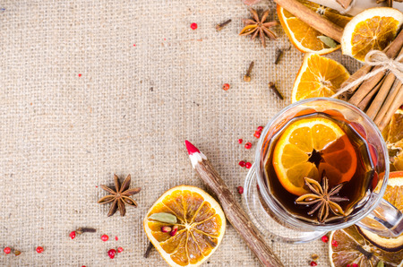 Dried oranges, cinnamon, cloves, cardamom, handmade milk chocolate with nuts, mulled wine, wooden pencil, list of paper on sackcloth, canvas. Christmas, New Year and winter. Free space for your text.の写真素材