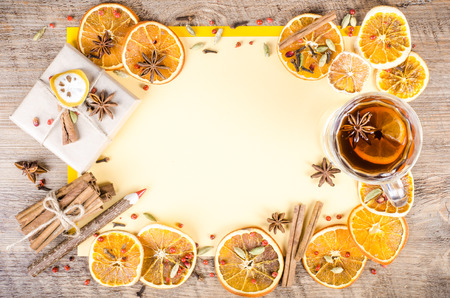 Dried oranges, cinnamon, cloves, cardamom, handmade milk chocolate with nuts, mulled wine, wooden pencil, list of paper on wooden background. Christmas, New Year and winter. Free space for your text.の写真素材