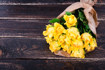 Yellow roses bouquet on the wooden backgroundの写真素材