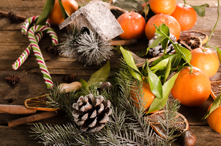 Christmas background - vintage wood, candy cane, house, cinnamon, star anise, sweet mandarins. Top view, blank spaceの写真素材