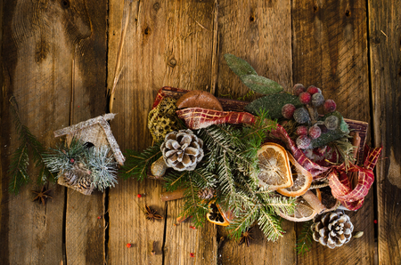 Christmas background - vintage wood, little house, cinnamon, star anise, dry oranges, cones, snow. New Year. Top view, blank spaceの写真素材