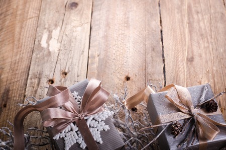 Rustic Christmas wreath with gifts on wooden background. Free space for your text.