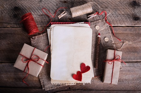Sewing set: fabrics, threads, pins, buttons, tape and handmade hearts on burlap, sackcloth background. Retro design effects.の写真素材