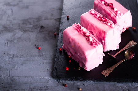 Valentine pink cakes and two teaspoons on white concrete background. Free space for your text.の写真素材