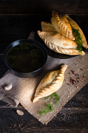 Chicken broth with pastries, mutton and mushroom pie. Free space for your textの写真素材