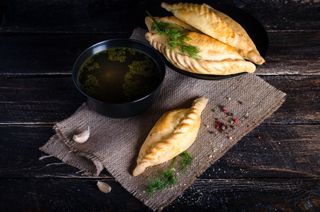 Chicken broth with pastries, mutton and mushroom pie. Free space for your textの写真素材